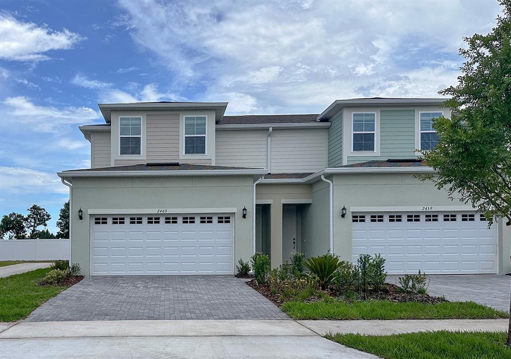 24101 Manuma Street, Unit SEMINOLE 2455 St. Cloud, FL 34771 - Photo 3 of 4 a view of a house with a yard and plants
