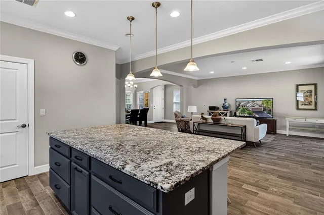 a kitchen with kitchen island a counter top space a sink stainless steel appliances and cabinets