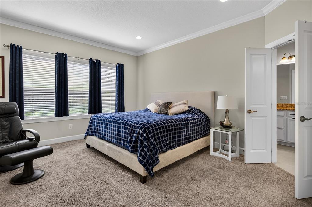 1284 Zeek Ridge Street Clermont, FL 34715 - Photo 16 of 35 a spacious bedroom with a bed and glass wall