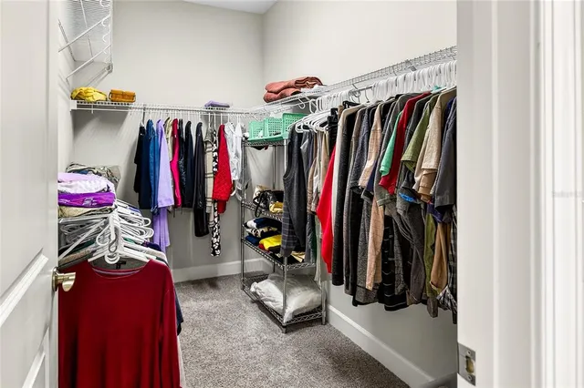 a view of walk in closet with clothes