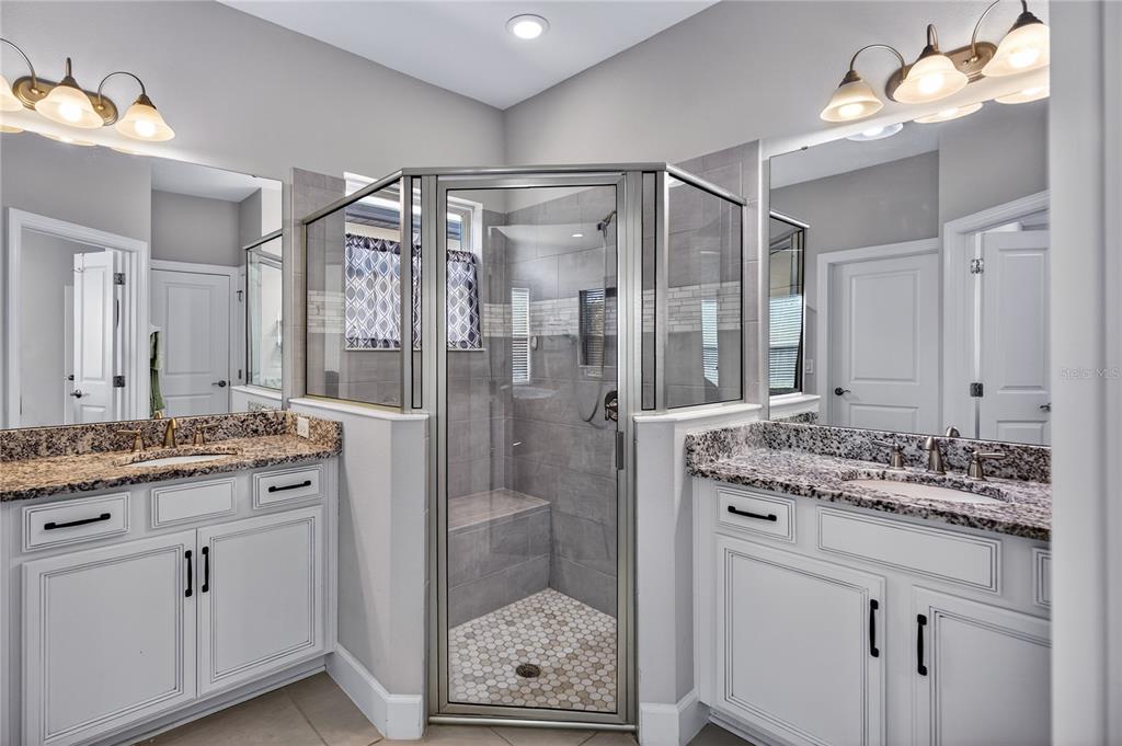 1284 Zeek Ridge Street Clermont, FL 34715 - Photo 18 of 35 a bathroom with a granite countertop sink a mirror and a shower