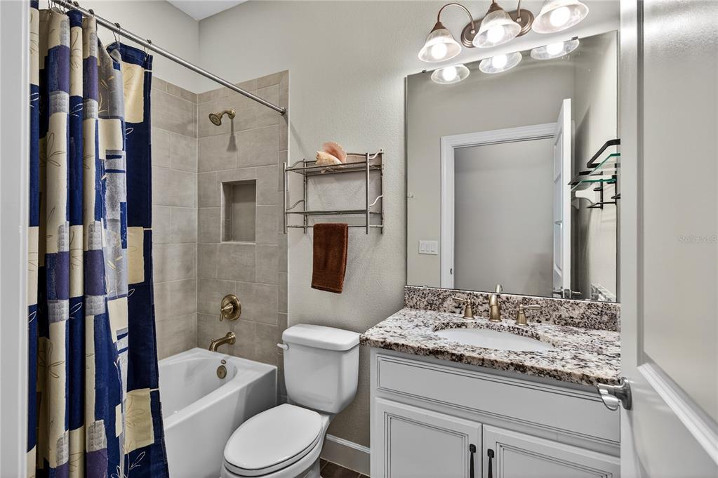 1284 Zeek Ridge Street Clermont, FL 34715 - Photo 22 of 35 a bathroom with a granite countertop sink a toilet and shower