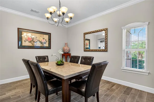 a view of a dining room with furniture a chandelier and wooden floor