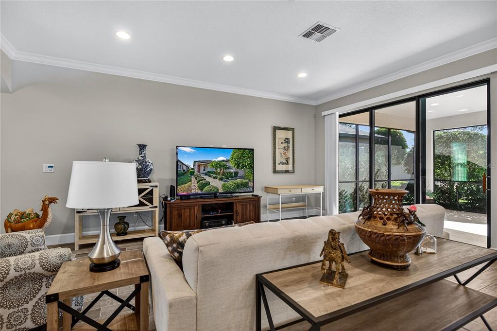 1284 Zeek Ridge Street Clermont, FL 34715 - Photo 7 of 35 a living room with furniture a flat screen tv and a large window