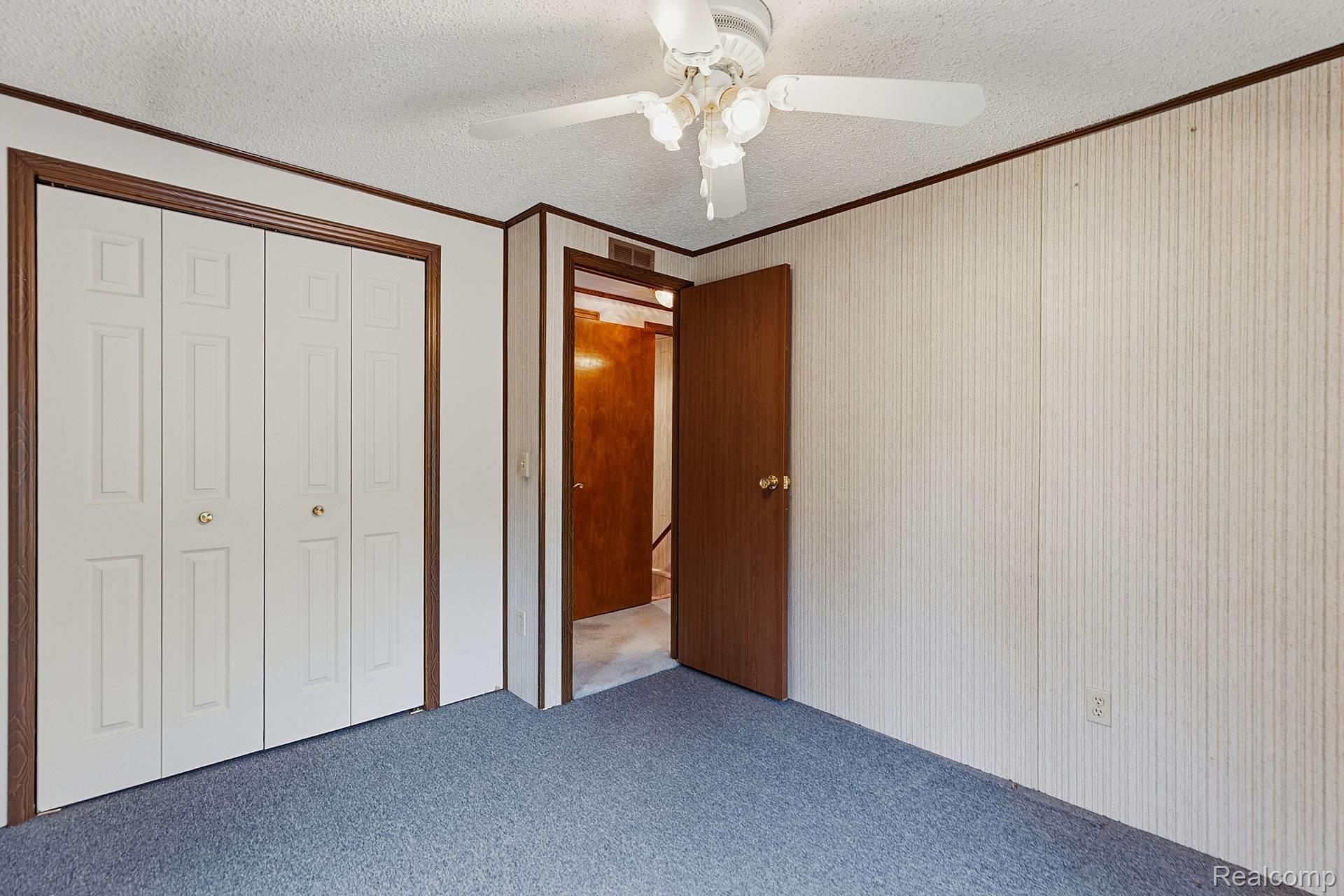 70919 Coon Creek Road Armada, MI 48005 - Photo 23 of 50 Unfurnished bedroom featuring a textured ceiling, carpet flooring, ornamental molding, a closet, and ceiling fan