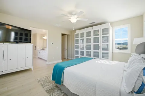a spacious bedroom with a large bed and a flat screen tv