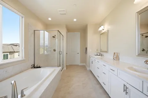 a bathroom with a tub a sink and mirror