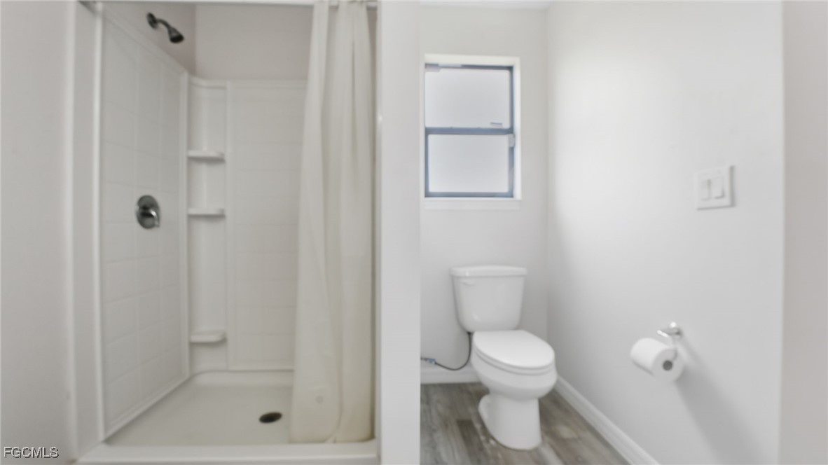 2701 East 18th Street Lehigh Acres, FL 33972 - Photo 12 of 23 a bathroom with a toilet shower and vanity