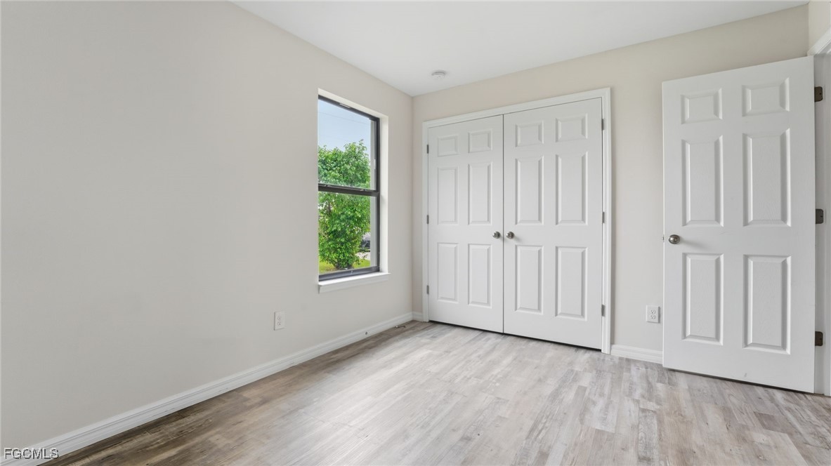 2701 East 18th Street Lehigh Acres, FL 33972 - Photo 18 of 23 an empty room with wooden floor and windows