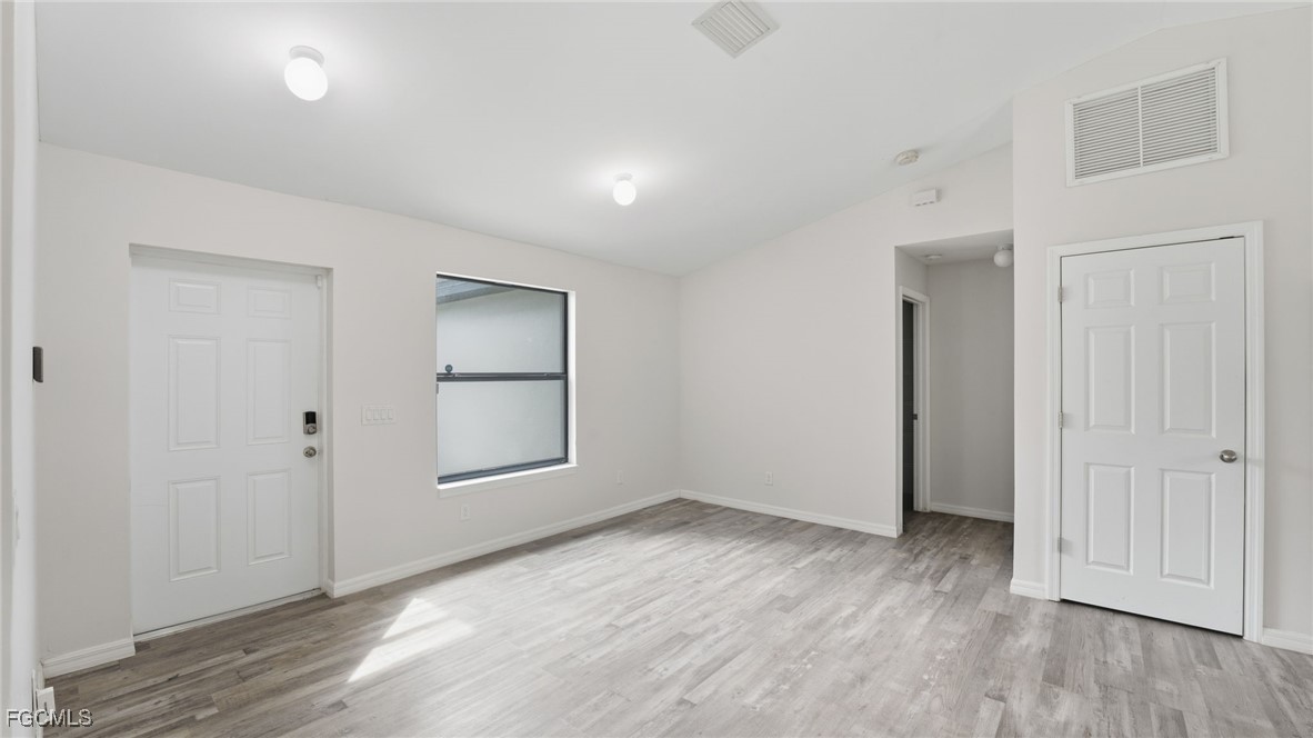 2701 East 18th Street Lehigh Acres, FL 33972 - Photo 21 of 23 an empty room with wooden floor and a window