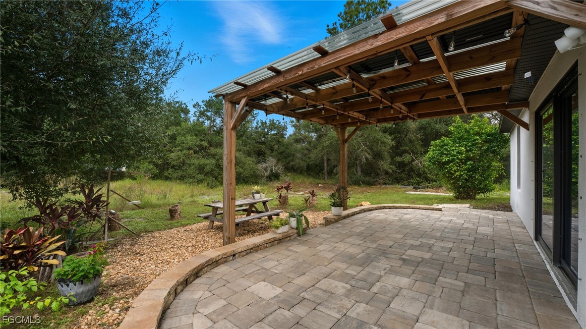 2701 East 18th Street Lehigh Acres, FL 33972 - Photo 3 of 23 a view of backyard with swimming pool and table and chairs under an umbrella
