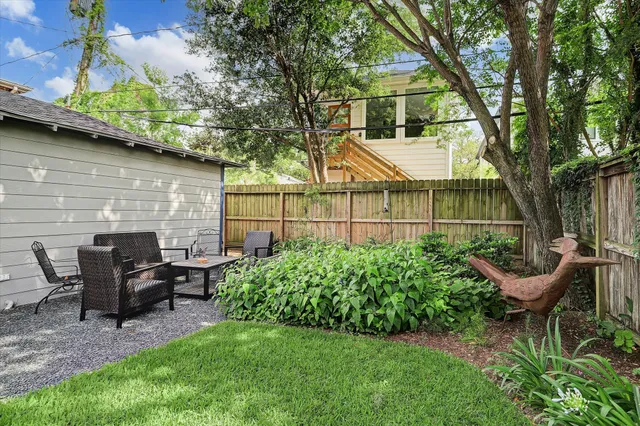 a view of a chair and table in backyard of the house