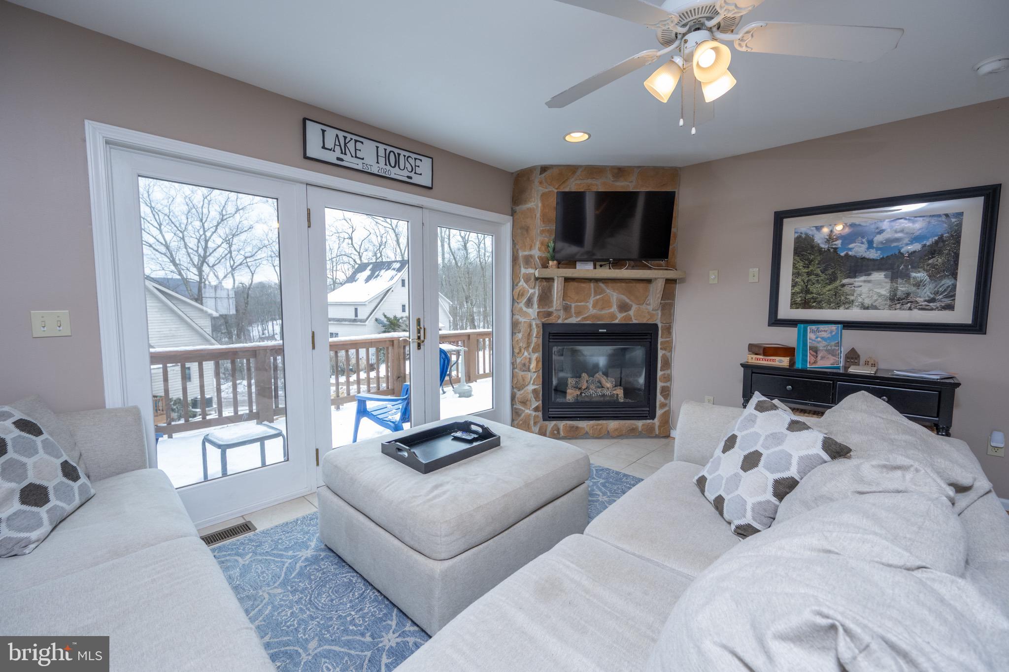 175 Roman Ridge Road, Unit 15 Oakland, MD 21550 - Photo 3 of 53 a living room with furniture large window and a fireplace