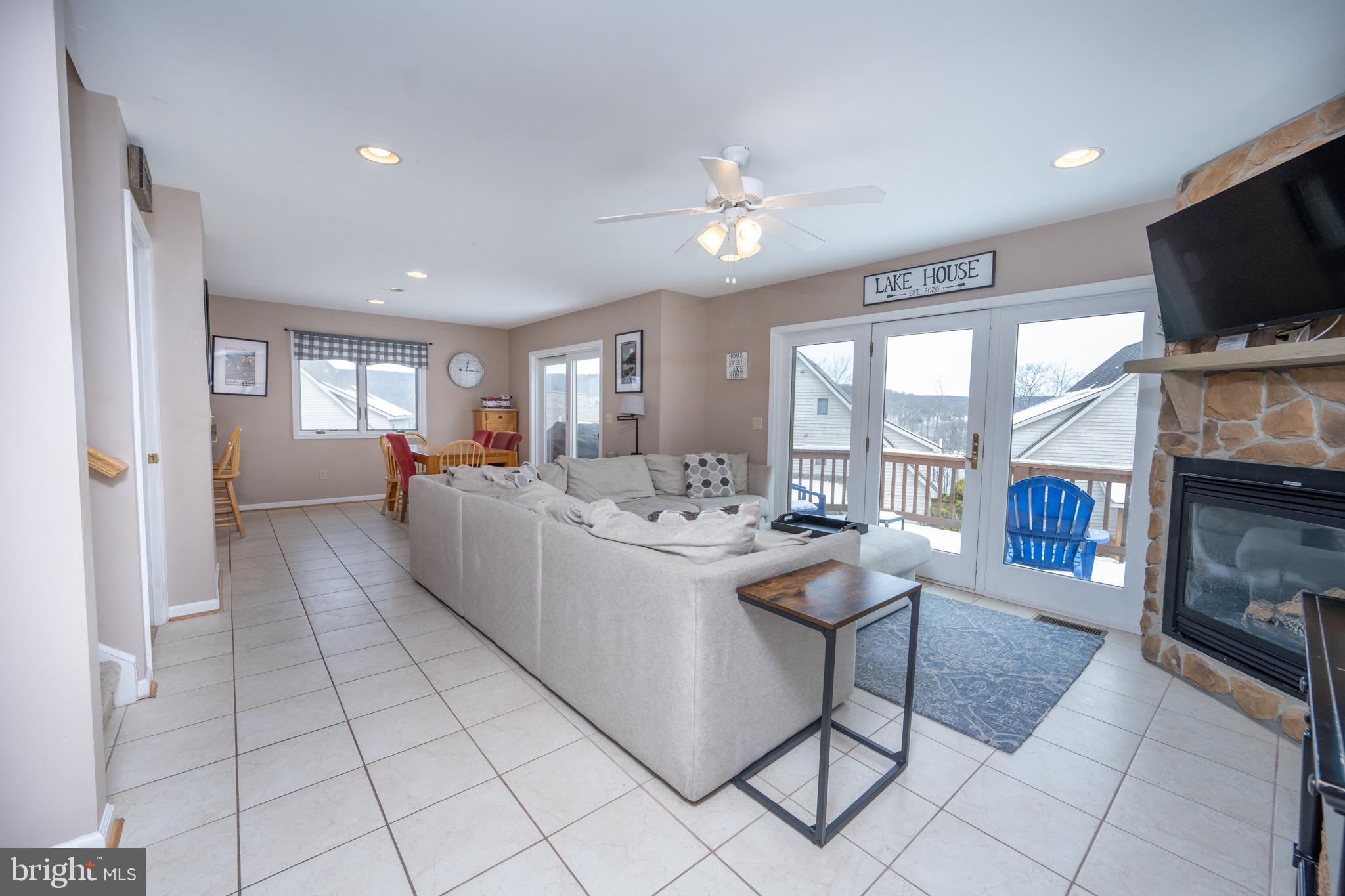 175 Roman Ridge Road, Unit 15 Oakland, MD 21550 - Photo 4 of 53 a living room with fireplace furniture and a flat screen tv