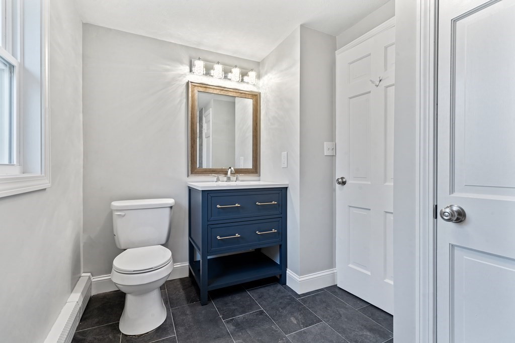 184 Booth Hill Road Scituate, MA 02066 - Photo 17 of 32 a bathroom with a toilet a sink and mirror