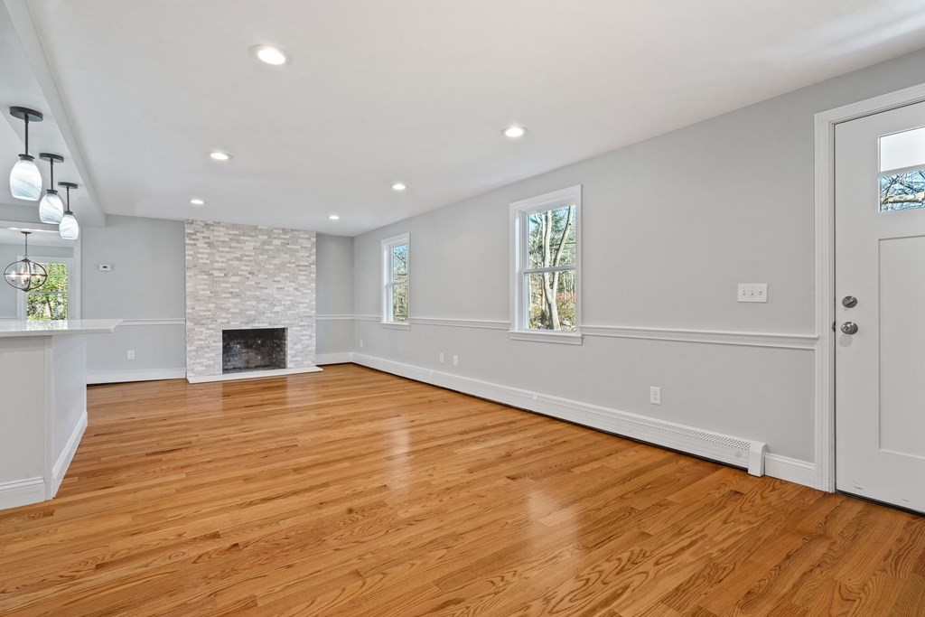 184 Booth Hill Road Scituate, MA 02066 - Photo 27 of 32 an empty room with wooden floor and fireplace