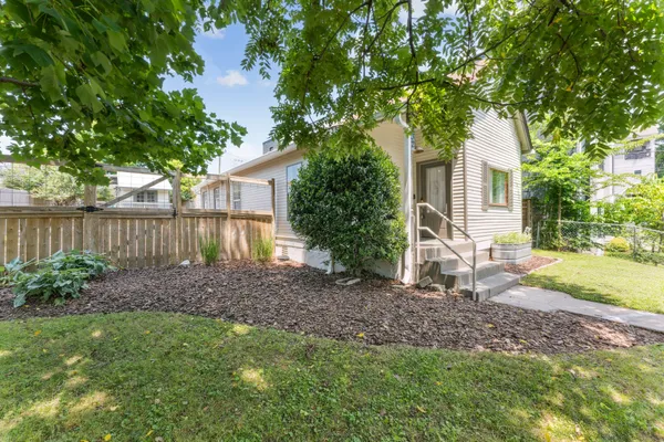 a view of a house with backyard and a tree