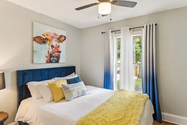 a bedroom with a large bed and a painting on the wall