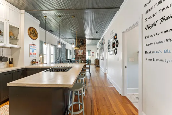 a kitchen with stainless steel appliances a table chairs and a stove top oven