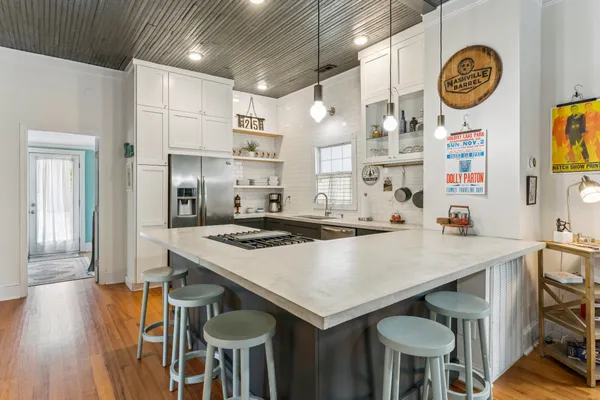 a kitchen with granite countertop a stove a refrigerator and cabinets