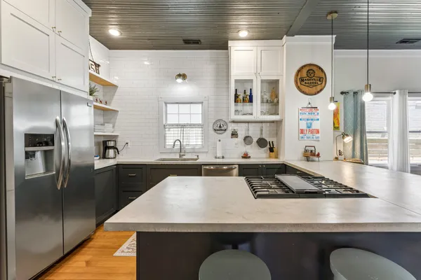 a living room with stainless steel furniture a table and kitchen view