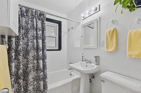 a bathroom with a sink a mirror a toilet and a bathtub