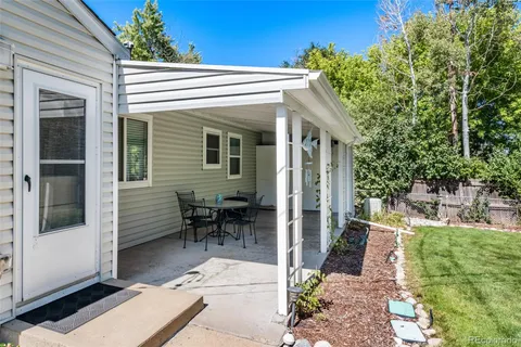 a porch with a table and chairs