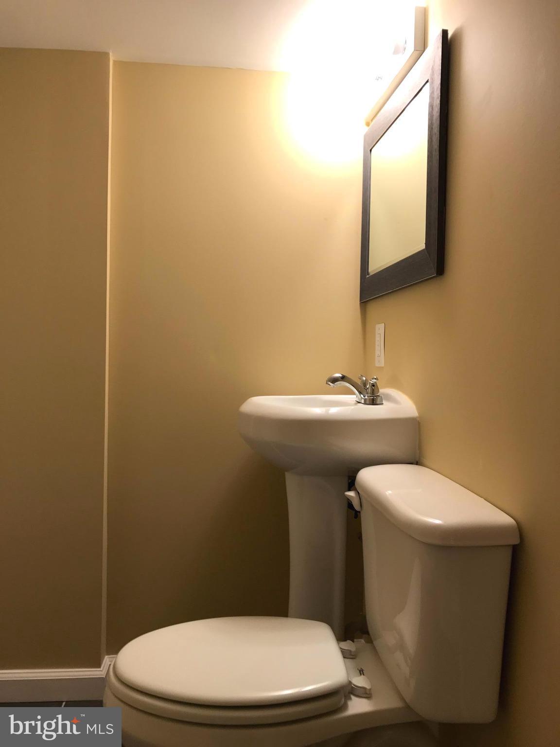 505 Welbrook Road Baltimore, MD 21221 - Photo 19 of 27 a white toilet sitting next to a bathroom sink