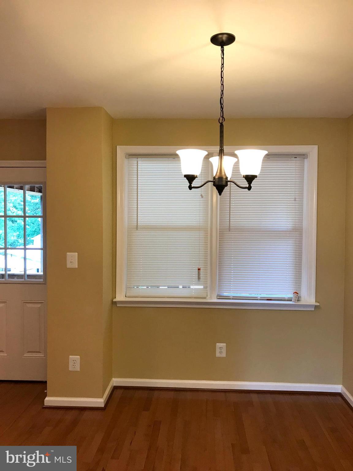 505 Welbrook Road Baltimore, MD 21221 - Photo 5 of 27 a view of a room with a chandelier fan and wooden floor