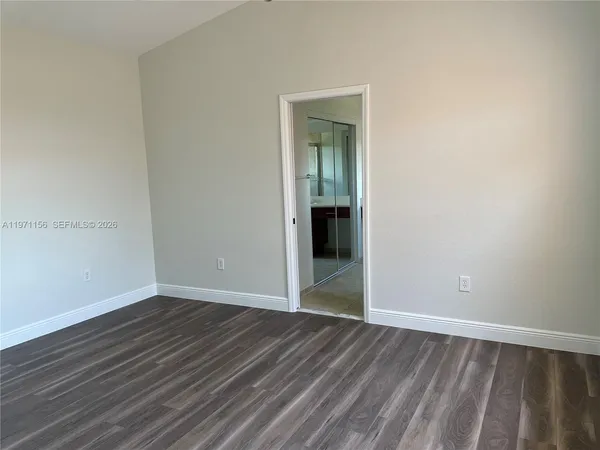 an empty room with wooden floor and closet