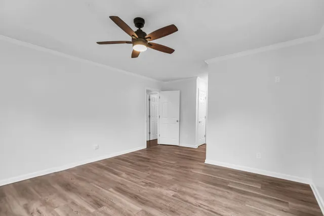 a view of a big room with wooden floor and windows