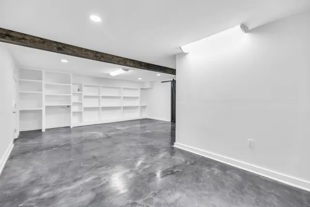 a view of an empty room with a cabinet and stairs