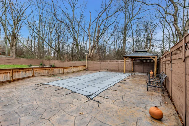 a view of a white house with a big yard and large trees