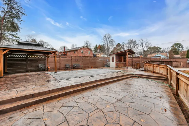 a view of a house with a big yard and large trees
