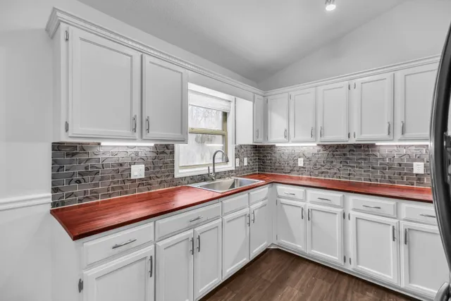 a kitchen with granite countertop white cabinets and white stainless steel appliances
