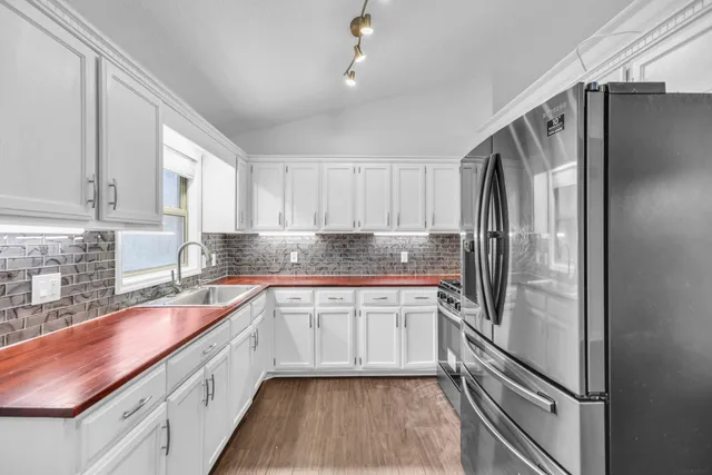 a kitchen with stainless steel appliances granite countertop a refrigerator sink and cabinets