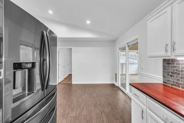an empty room with wooden floor and cabinet