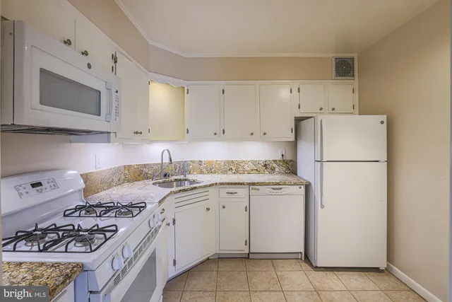 a kitchen with a stove a refrigerator and a sink