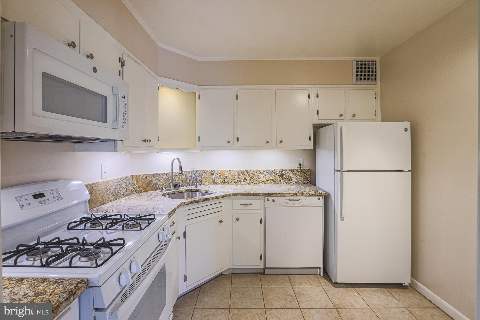 3535 Chevy Chase Lake Drive, Unit 310 Chevy Chase, MD 20815 - Photo 11 of 40 a kitchen with a stove a refrigerator and a sink
