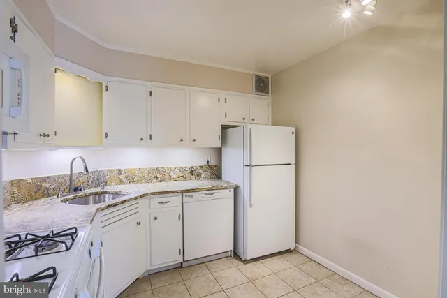 a kitchen with a sink a refrigerator and cabinets
