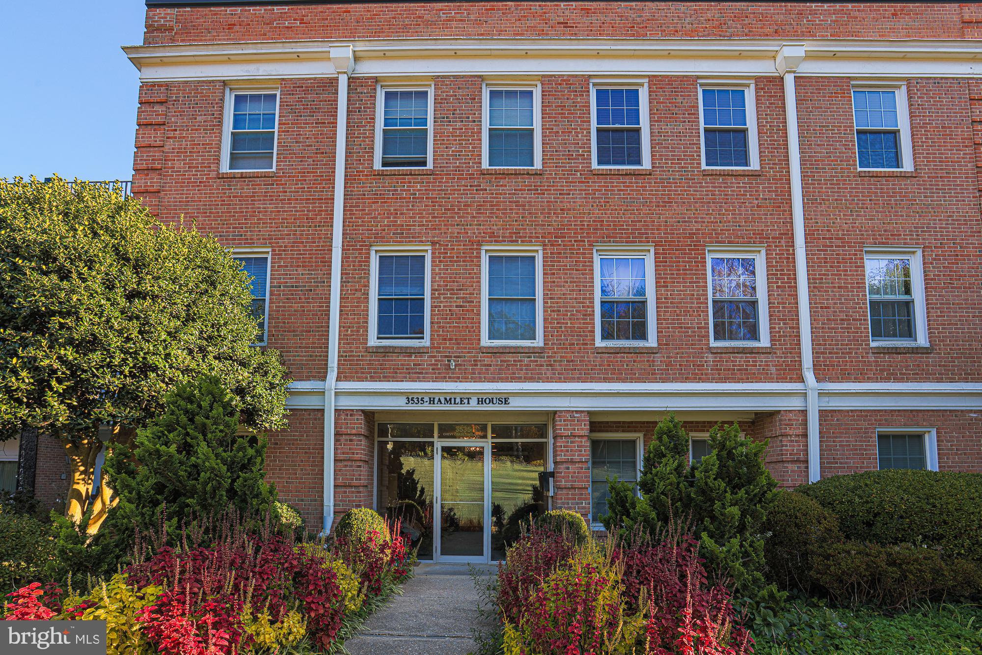 3535 Chevy Chase Lake Drive, Unit 310 Chevy Chase, MD 20815 - Photo 4 of 40 a front view of a house with a yard and outdoor seating