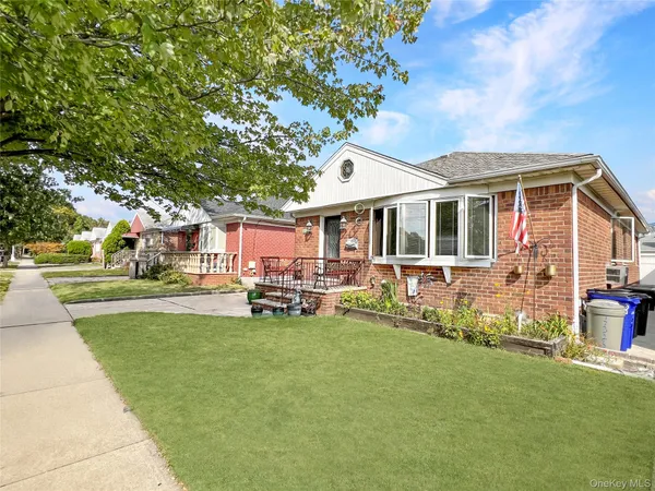 a front view of a house with a garden and trees