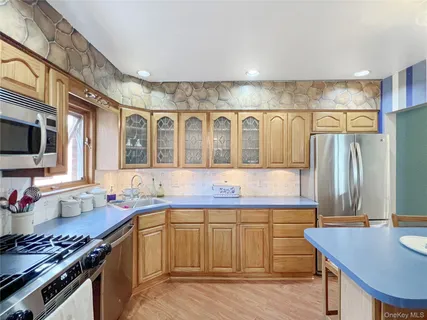 a kitchen with stainless steel appliances a stove a sink dishwasher and cabinets with wooden floor