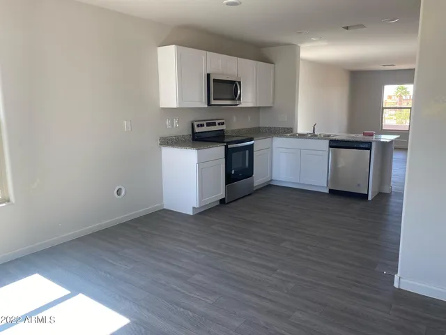 a kitchen with granite countertop a stove top oven and sink