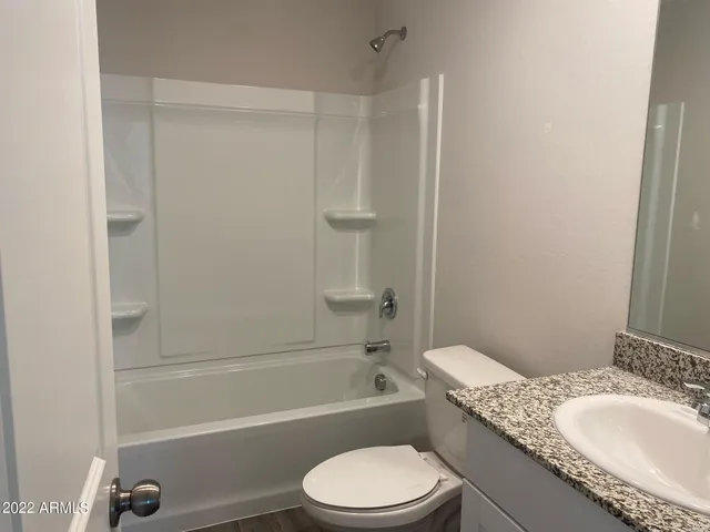 a bathroom with a granite countertop toilet a sink and bathtub