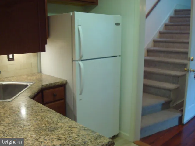 a view of a kitchen with wooden floor and electronic appliances