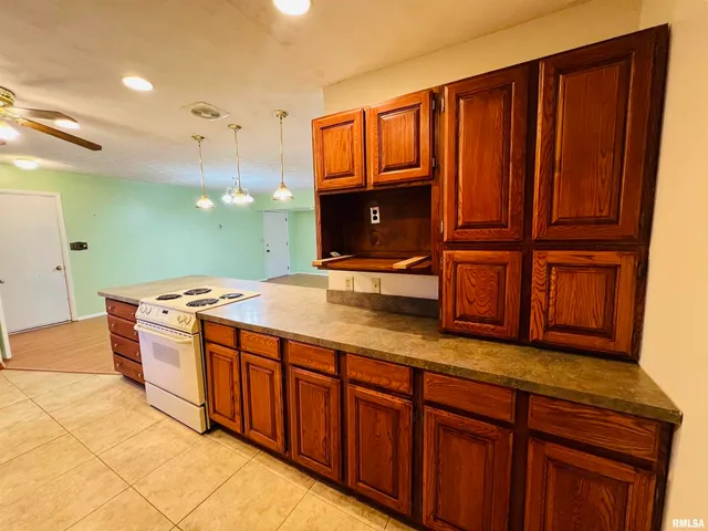 a view of kitchen with granite countertop window and refrigerator