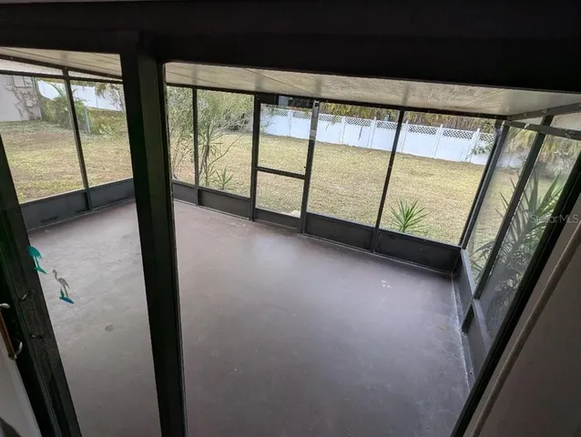 a view of an empty room with large windows