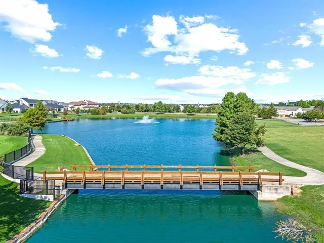 a view of a lake with lawn chairs and a fire pit