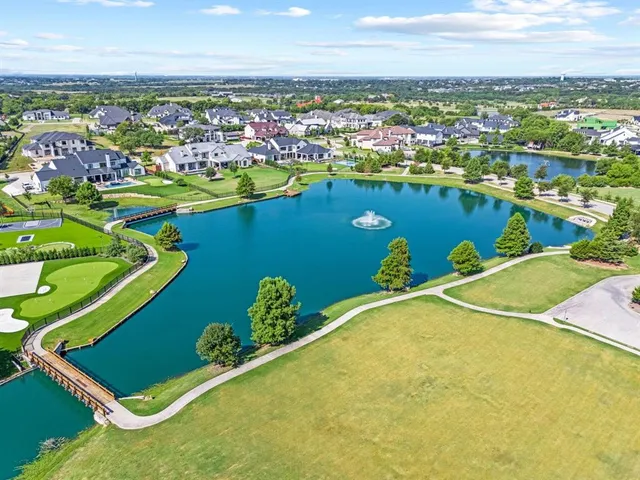 an aerial view of a residential houses with outdoor space and ocean view
